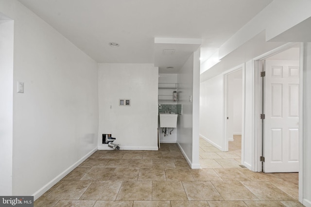 laundry room with a sink, baseboards, hookup for a washing machine, and laundry area