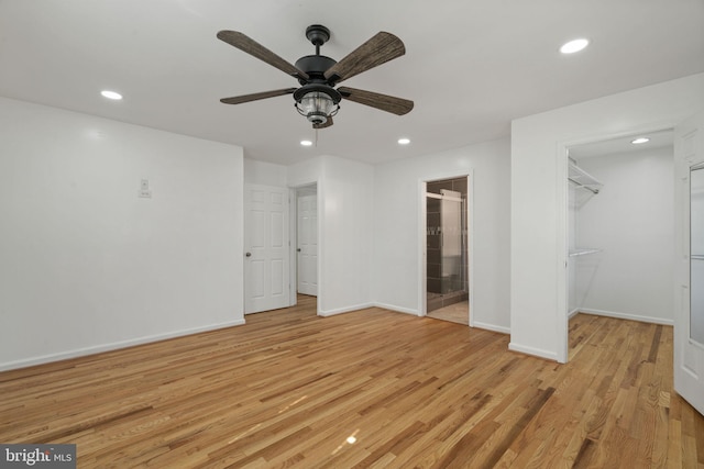 unfurnished bedroom with a walk in closet, recessed lighting, and light wood-style floors