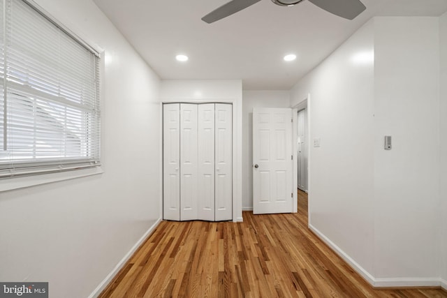 unfurnished bedroom with recessed lighting, light wood-style floors, a closet, and baseboards