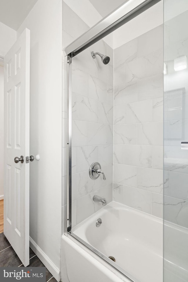 full bathroom with baseboards, bathing tub / shower combination, and wood finished floors