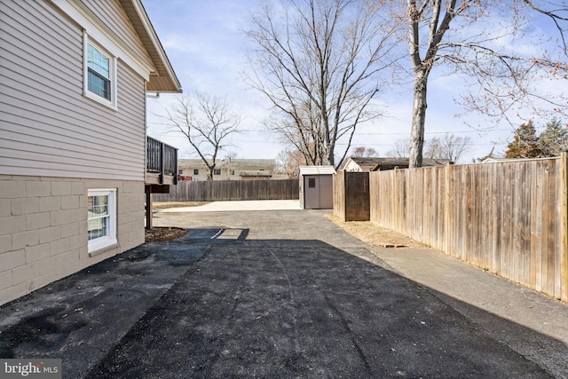 view of yard with a storage shed, an outdoor structure, a fenced backyard, and a patio