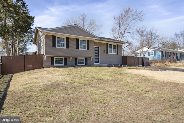 split foyer home featuring a front yard and fence