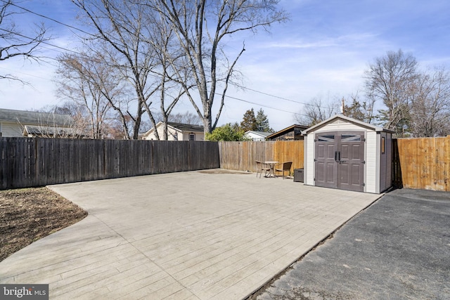 view of patio featuring an outbuilding, a shed, and a fenced backyard