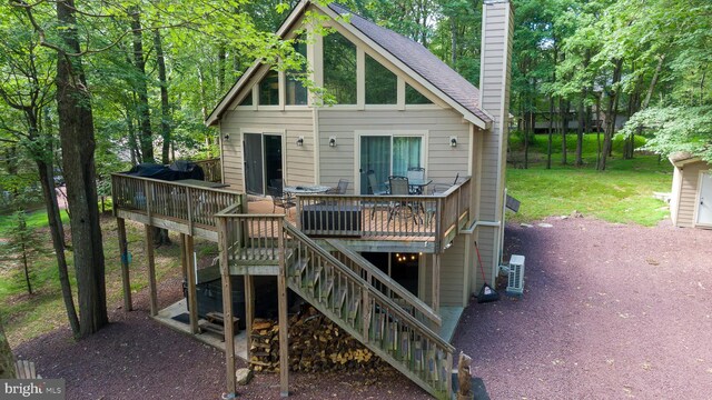 exterior space featuring a wooden deck, a yard, a shingled roof, stairs, and a chimney