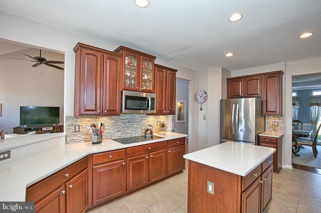 kitchen with backsplash, recessed lighting, stainless steel appliances, light countertops, and glass insert cabinets