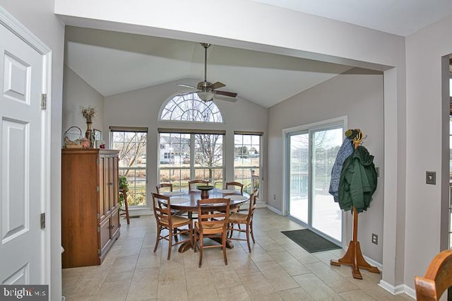 dining space featuring lofted ceiling, light tile patterned flooring, a ceiling fan, and baseboards