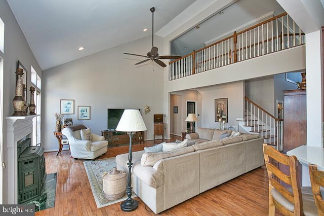 living room with high vaulted ceiling, wood finished floors, recessed lighting, stairway, and ceiling fan