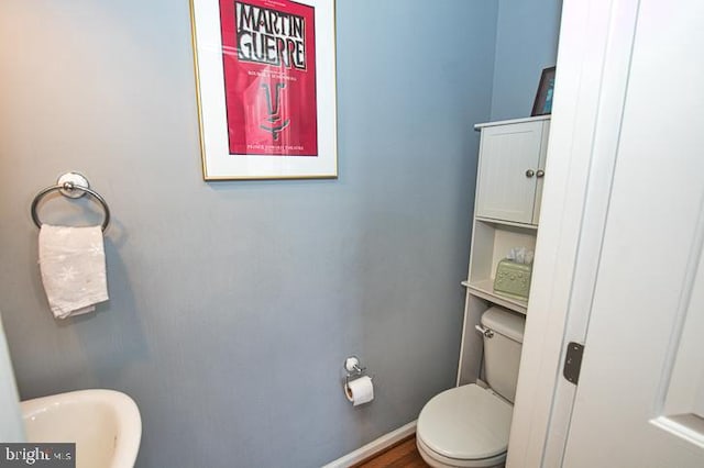 bathroom featuring a sink, baseboards, and toilet