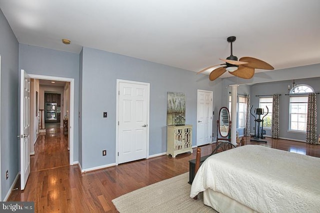 bedroom featuring baseboards, wood finished floors, and a ceiling fan