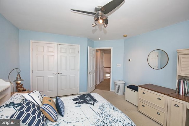 bedroom featuring baseboards, light colored carpet, a closet, and ceiling fan