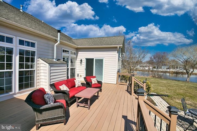 wooden deck with a water view, a lawn, and an outdoor hangout area