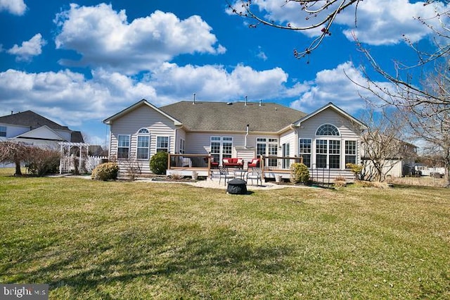 back of property featuring a wooden deck and a yard