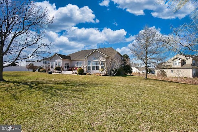 rear view of house featuring a patio area and a yard