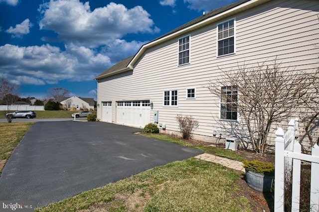 view of home's exterior with aphalt driveway and a garage