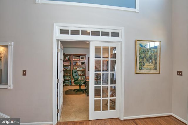 doorway to outside featuring french doors, baseboards, and wood finished floors