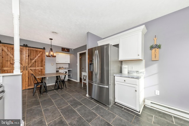 kitchen featuring a baseboard radiator, stainless steel refrigerator with ice dispenser, white cabinetry, a barn door, and tasteful backsplash