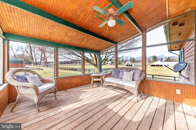 sunroom / solarium featuring beamed ceiling, wood ceiling, and a ceiling fan