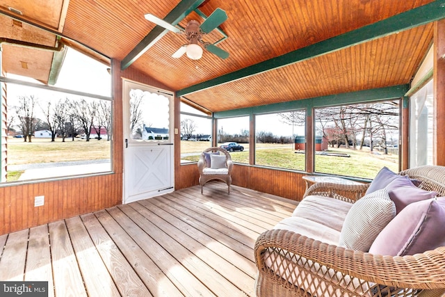 sunroom / solarium with lofted ceiling with beams, a ceiling fan, and wooden ceiling