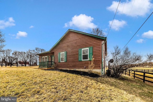 view of side of home with a yard and fence