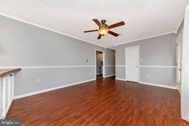 unfurnished room with a ceiling fan, crown molding, wood finished floors, and baseboards