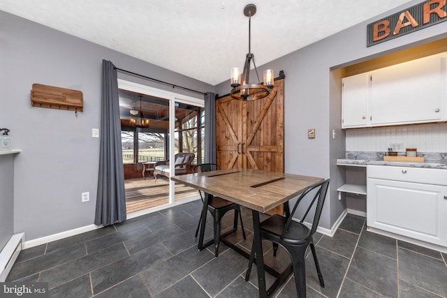 dining room with a barn door, baseboards, a chandelier, and a baseboard radiator