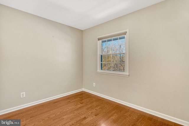 empty room featuring baseboards and wood finished floors