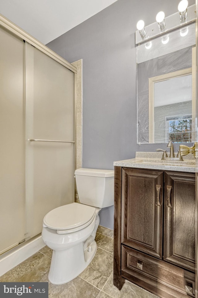 bathroom featuring a stall shower, toilet, and vanity