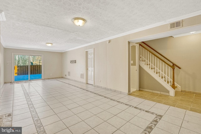 tiled spare room with visible vents, a textured ceiling, ornamental molding, and stairway