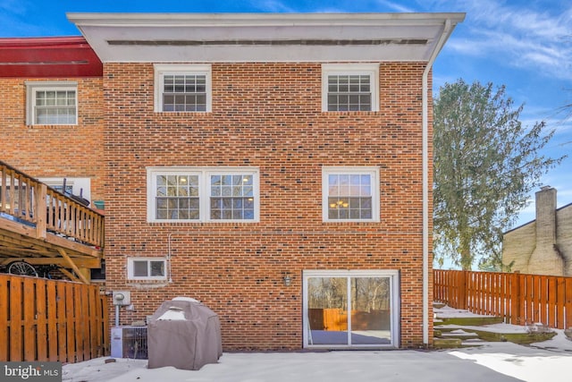 back of property with central AC unit, a fenced backyard, and brick siding