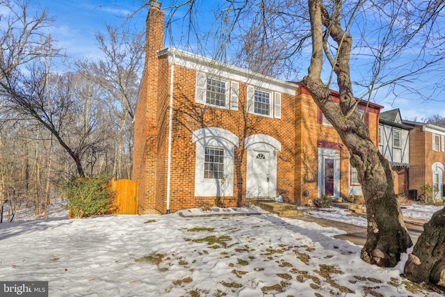 view of front of property featuring brick siding and a chimney