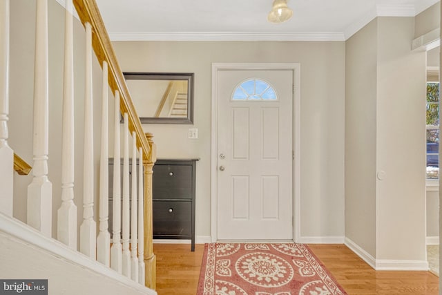 entryway featuring light wood-style flooring, stairs, baseboards, and ornamental molding