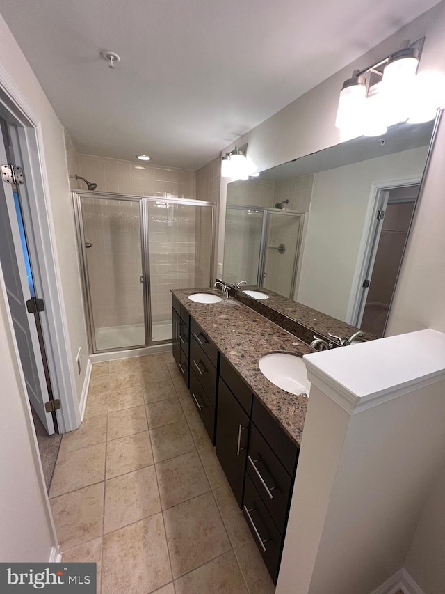 bathroom featuring a sink, a stall shower, and tile patterned flooring