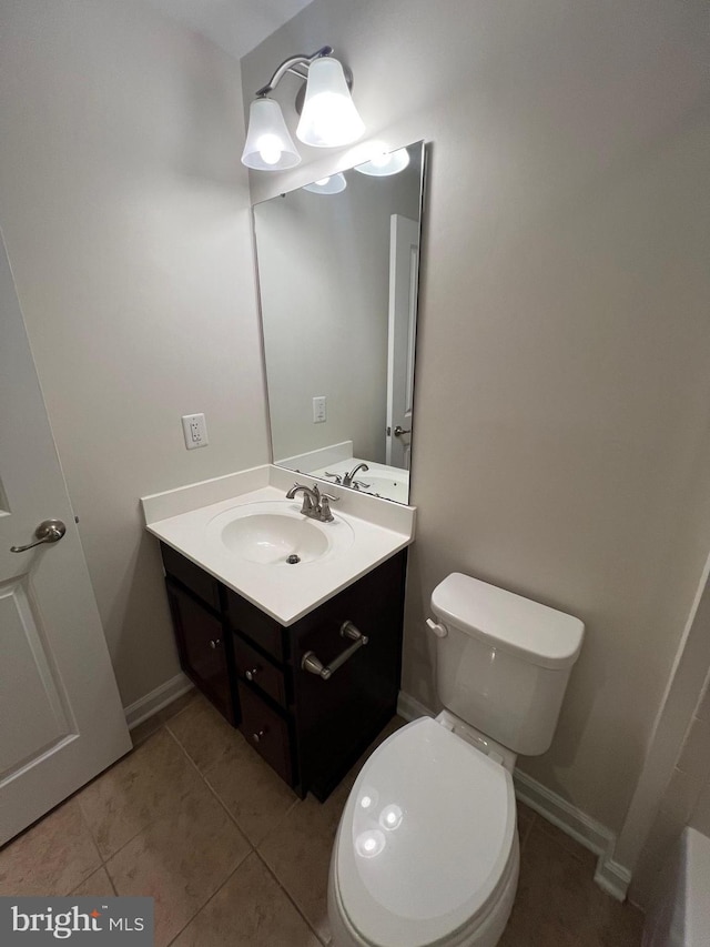 bathroom featuring tile patterned floors, baseboards, toilet, and vanity