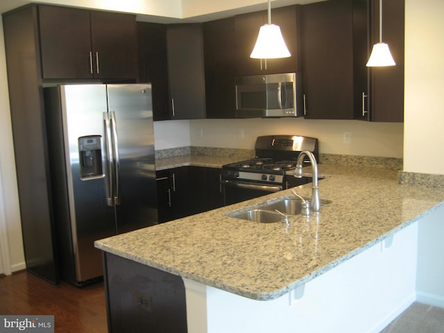 kitchen featuring dark brown cabinets, light stone countertops, decorative light fixtures, a peninsula, and stainless steel appliances