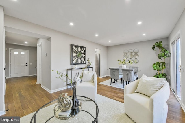 living room featuring hardwood / wood-style flooring, recessed lighting, and baseboards