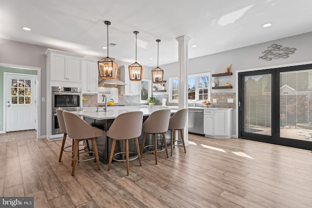 kitchen featuring white cabinetry, open shelves, light countertops, and stainless steel appliances