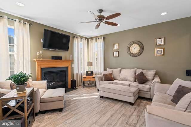 living room with light wood finished floors, plenty of natural light, recessed lighting, and a fireplace with flush hearth