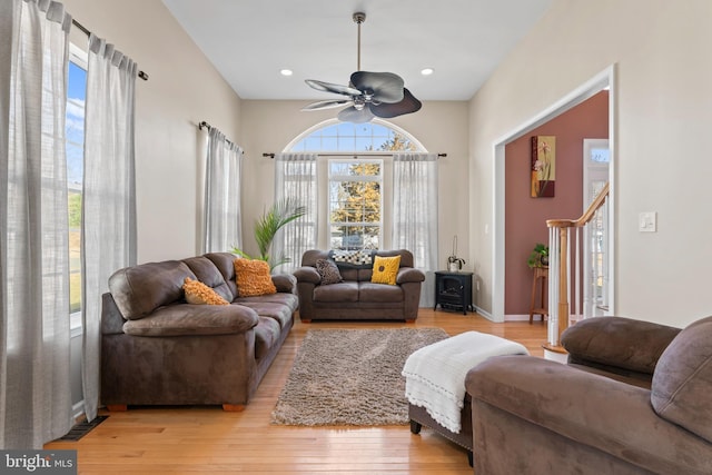 living area with a wealth of natural light, light wood-type flooring, ceiling fan, and recessed lighting