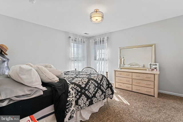 bedroom with light colored carpet and baseboards