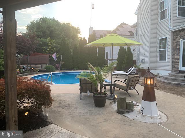 outdoor pool featuring a patio and a fire pit