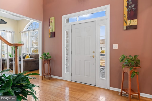 foyer featuring stairway, baseboards, and light wood-style floors