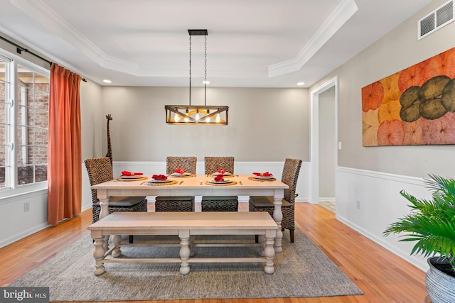 dining space featuring a raised ceiling, visible vents, and a wealth of natural light