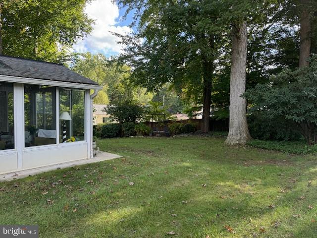 view of yard with fence and a sunroom