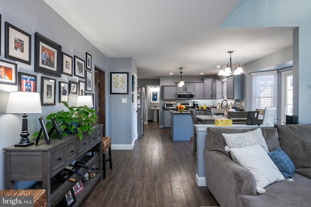 living room with recessed lighting, a notable chandelier, dark wood-style floors, and baseboards