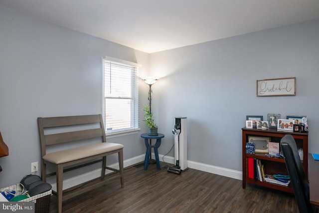 living area with baseboards and dark wood finished floors