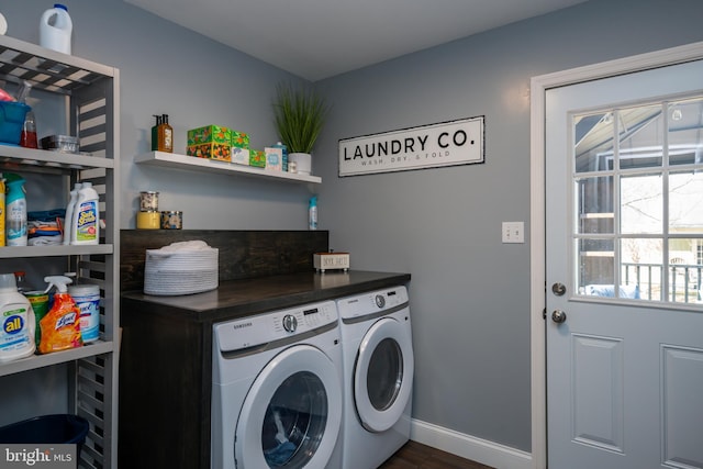 laundry area with laundry area, washing machine and dryer, baseboards, and dark wood-type flooring