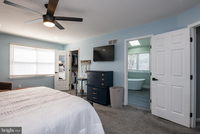 bedroom featuring visible vents, a ceiling fan, a closet, dark colored carpet, and a spacious closet