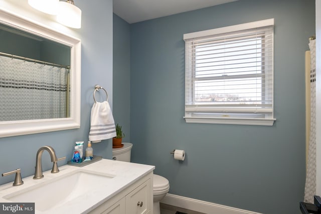 full bath featuring vanity, toilet, and baseboards