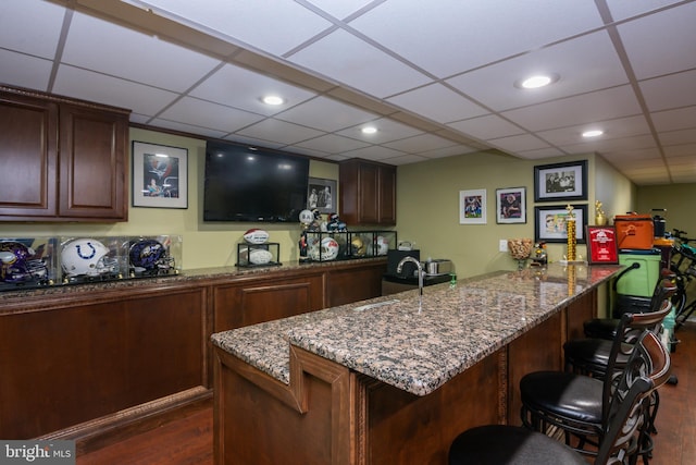 bar featuring a sink, recessed lighting, indoor wet bar, a paneled ceiling, and dark wood-style flooring