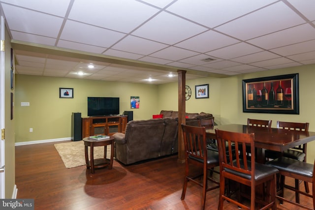 dining space with a paneled ceiling, baseboards, and wood finished floors